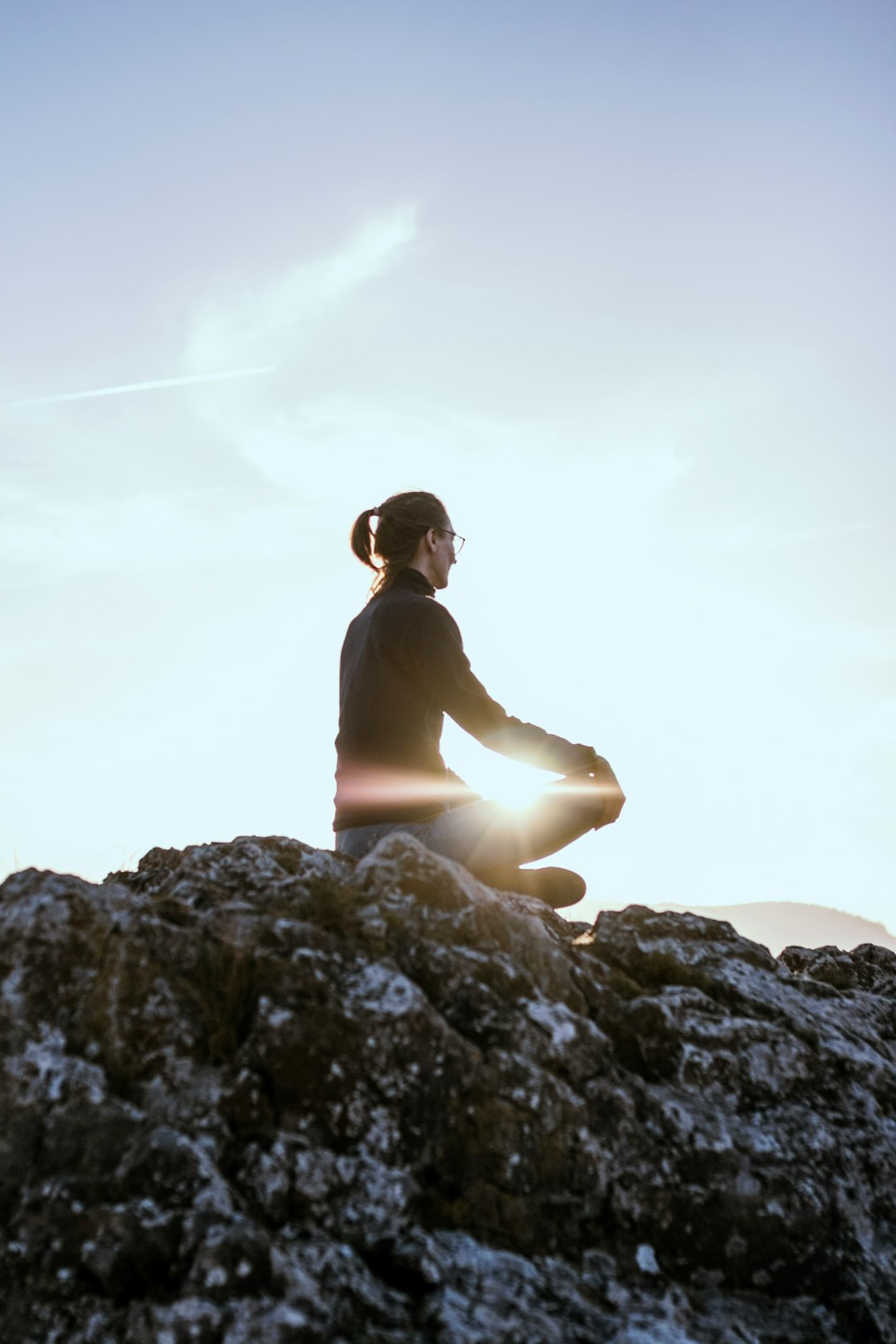 Woman meditating in the top of the mountain