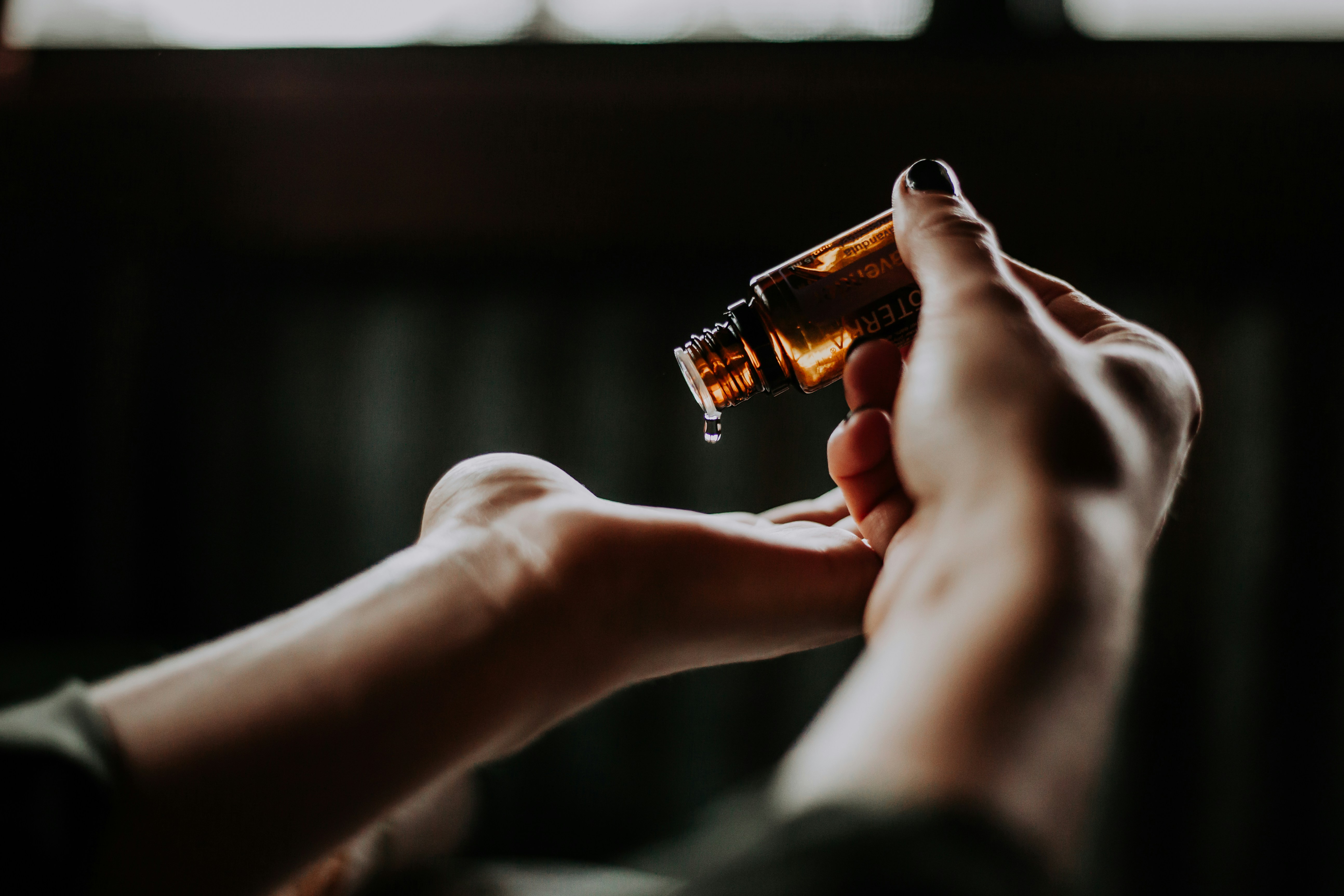 Image of a dropping oil in hand